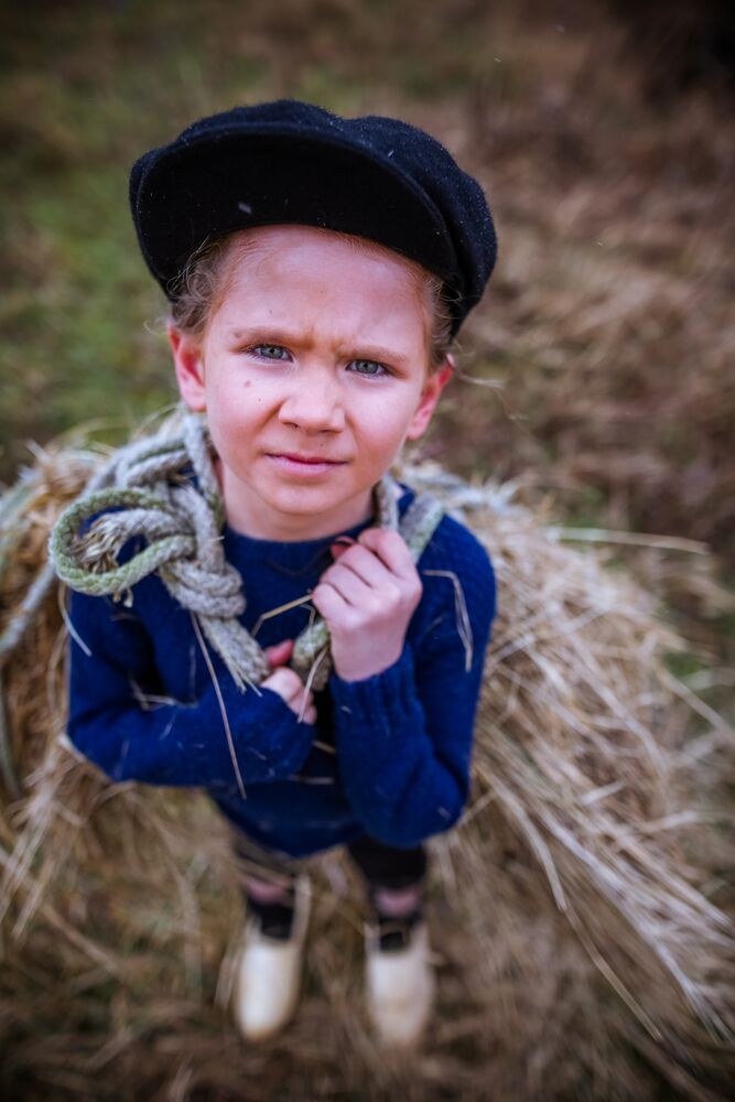 Portret van een kind op een baal stro